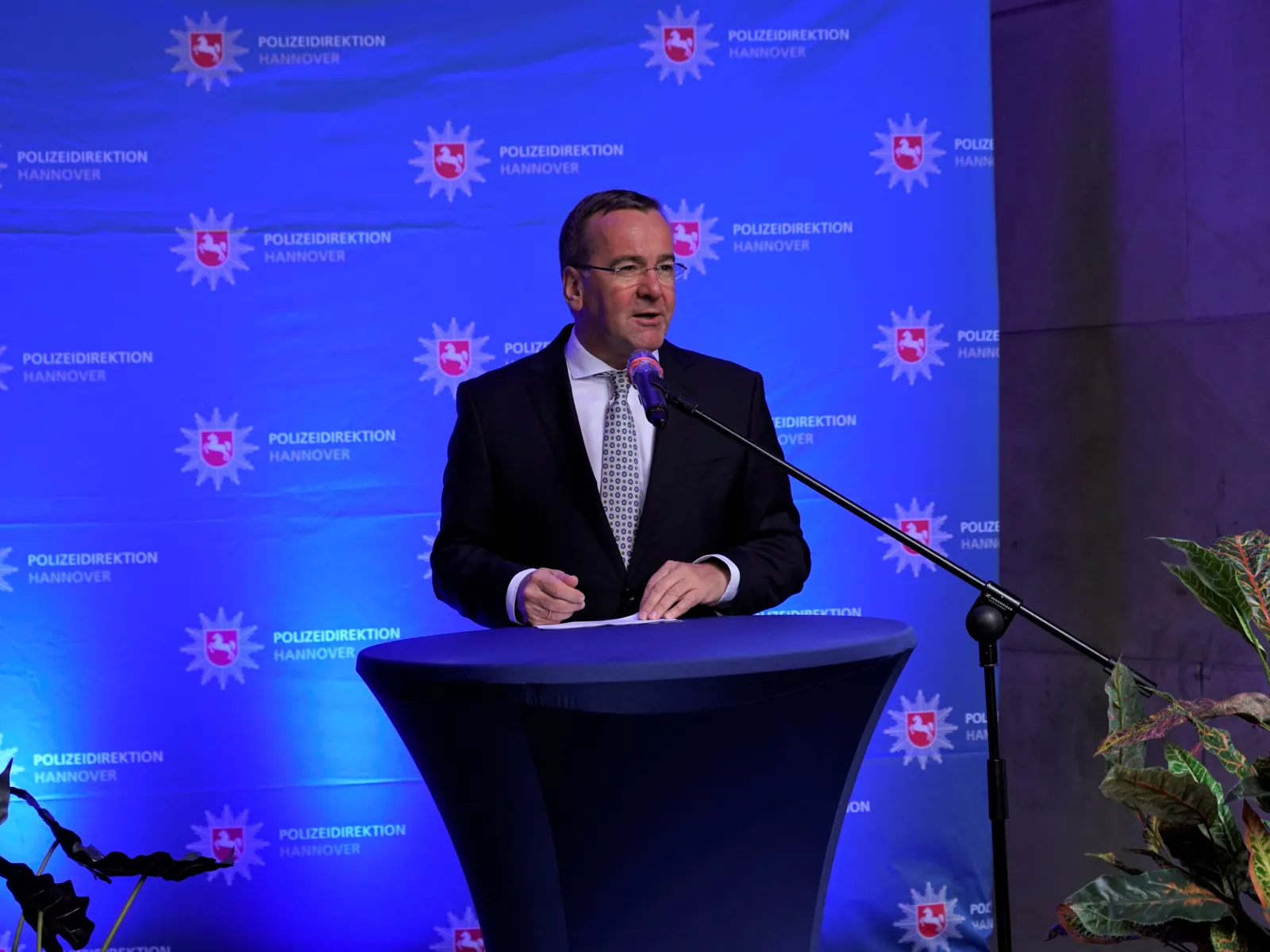 Ein Mann steht vor einem Podest und hält eine Rede